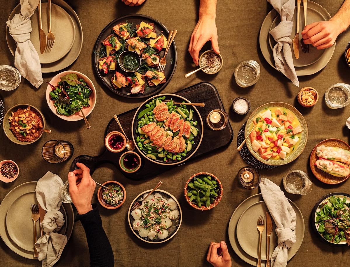 The Sparkcrplanet team gathered around a table with seasonal produce in Queenstown